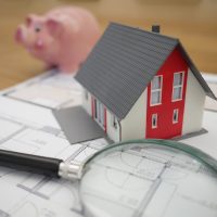 white and red wooden house beside grey framed magnifying glass