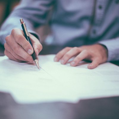 man writing on paper